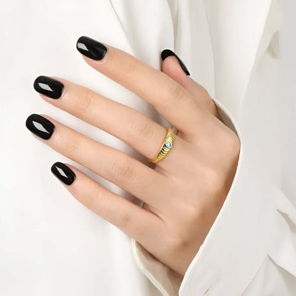 model wearing the Iridian Band featuring marquise blue zircon on a 18k gold etched band.